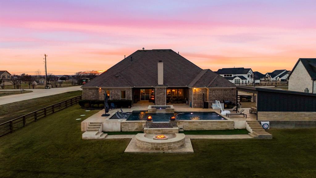 7751 Faught Road Northlake, TX 76226 - Photo 4 of 39 Brick exterior residence featuring a multi-level patio with a swimming pool, spa, and fire pit
