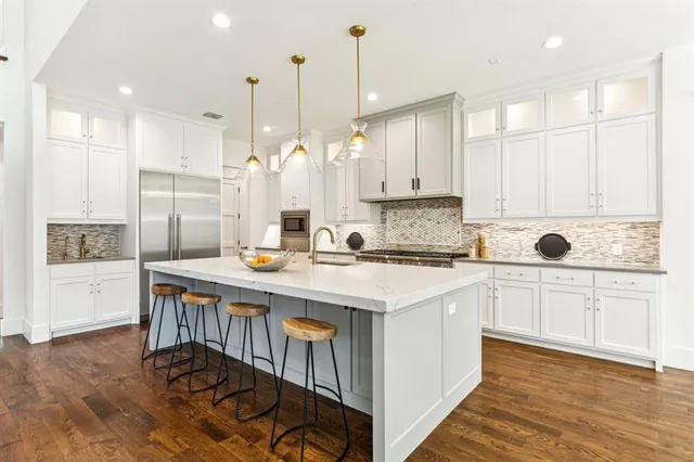 a kitchen with stainless steel appliances granite countertop a stove a sink and a refrigerator