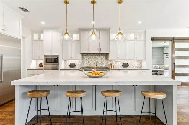 a large kitchen with kitchen island a large counter space a sink appliances and a counter space