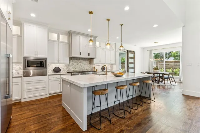 a kitchen with granite countertop a sink stove and refrigerator