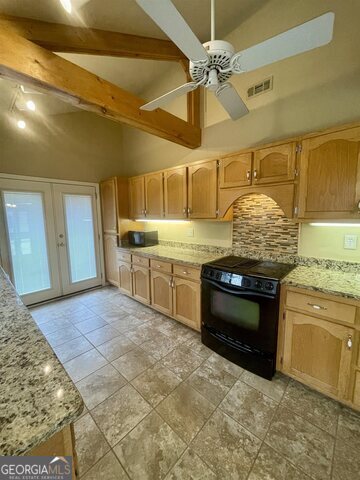 242 Ebenezer Church Road Fayetteville, GA 30215 - Photo 9 of 46 a kitchen with stainless steel appliances granite countertop a stove a sink and a refrigerator
