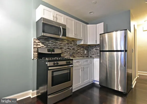 a kitchen with appliances a microwave and cabinets