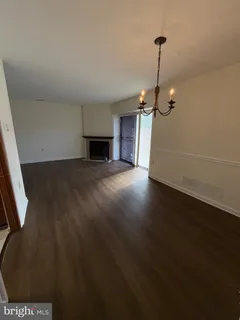 a view of empty room with wooden floor fireplace and window