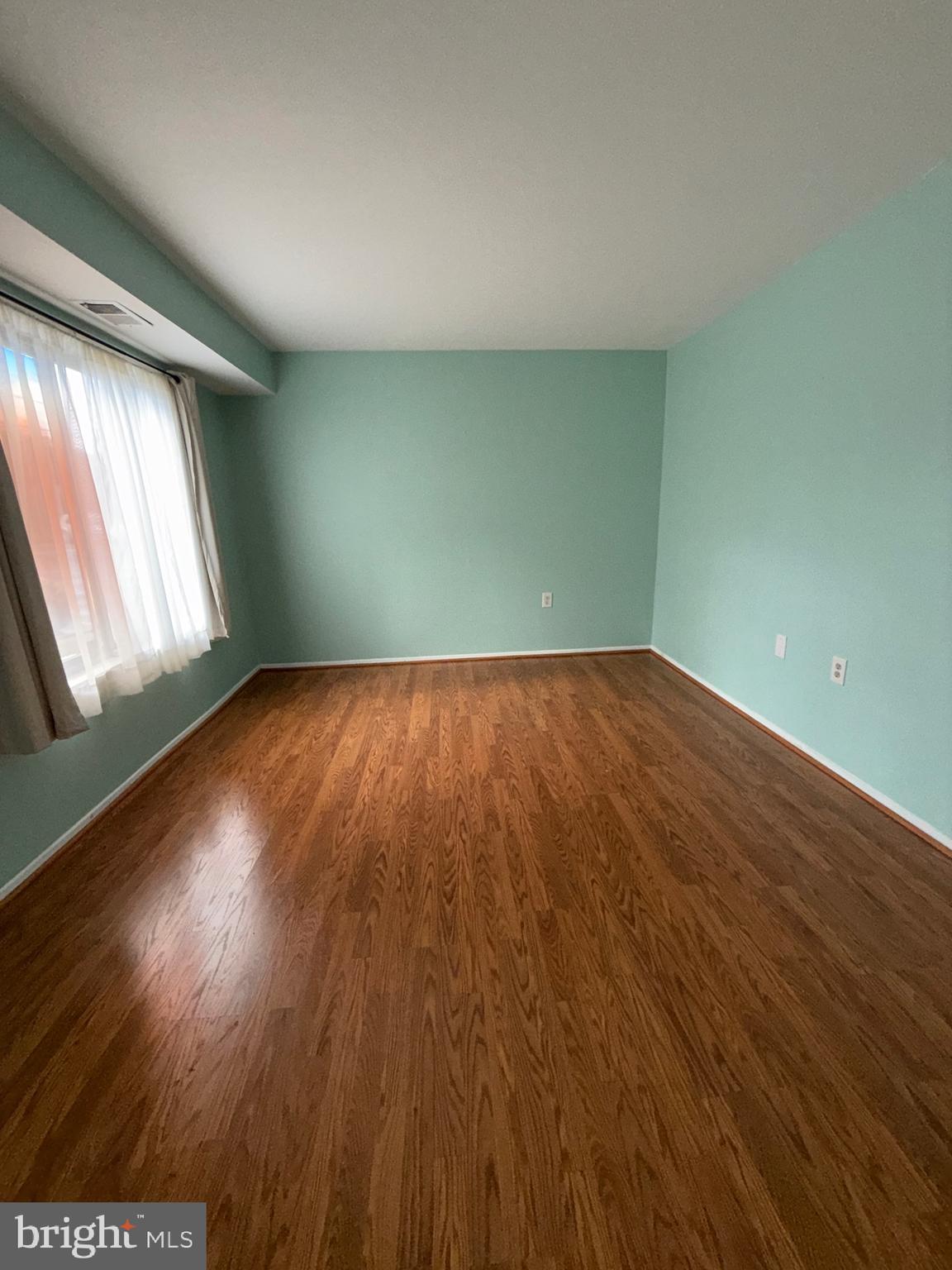 118 Mountain Road, Unit 1A Glen Burnie, MD 21060 - Photo 13 of 16 an empty room with wooden floor and windows