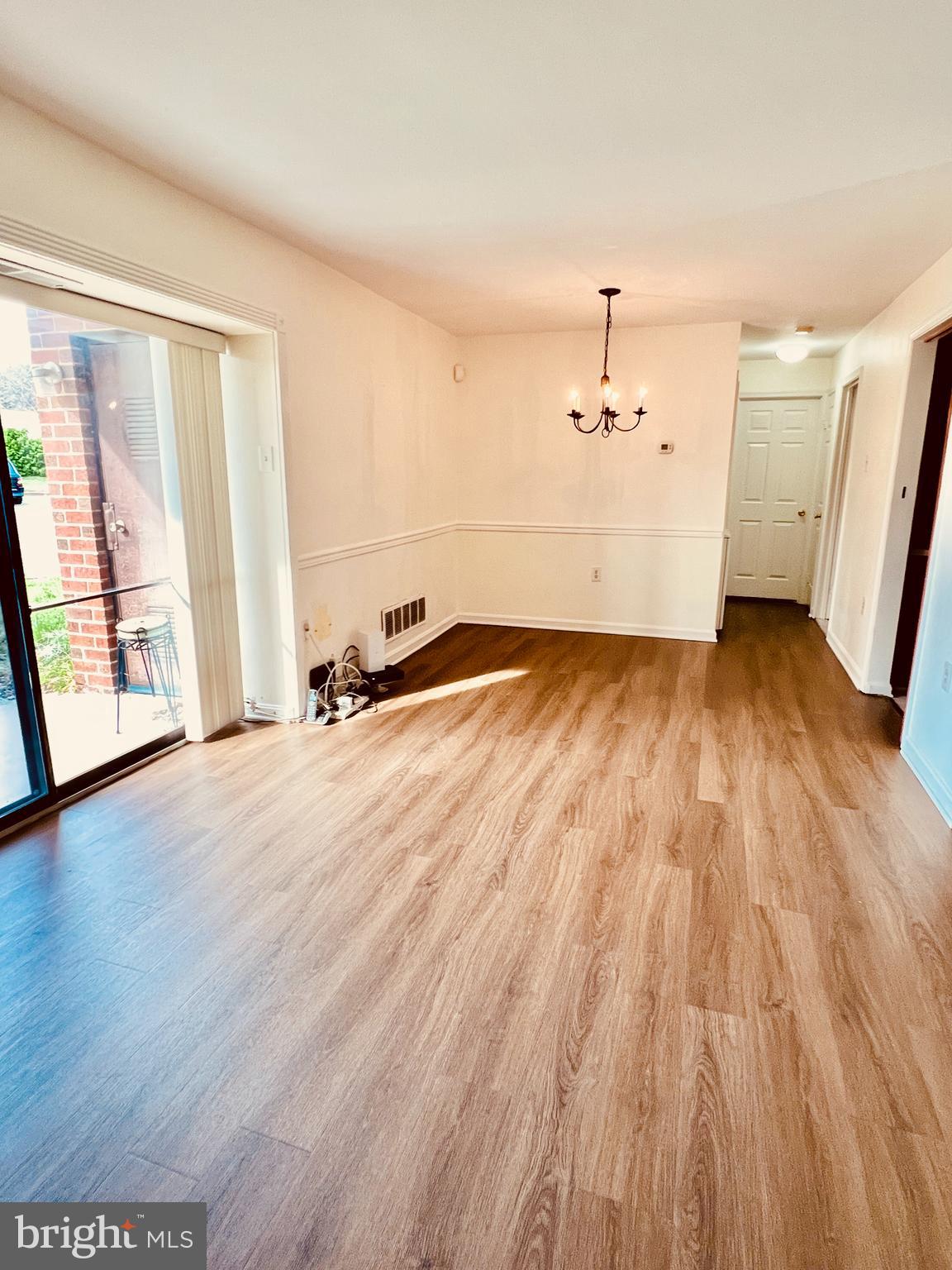 118 Mountain Road, Unit 1A Glen Burnie, MD 21060 - Photo 6 of 16 an empty room with wooden floor and windows