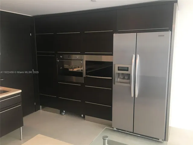 a view of a room with a chandelier fan and wooden floor