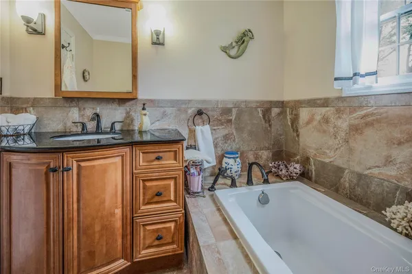 a bathroom with a granite countertop sink a mirror and shower