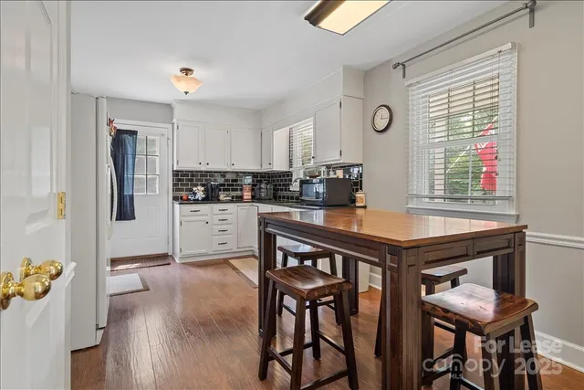 a kitchen with a table chairs refrigerator and cabinets