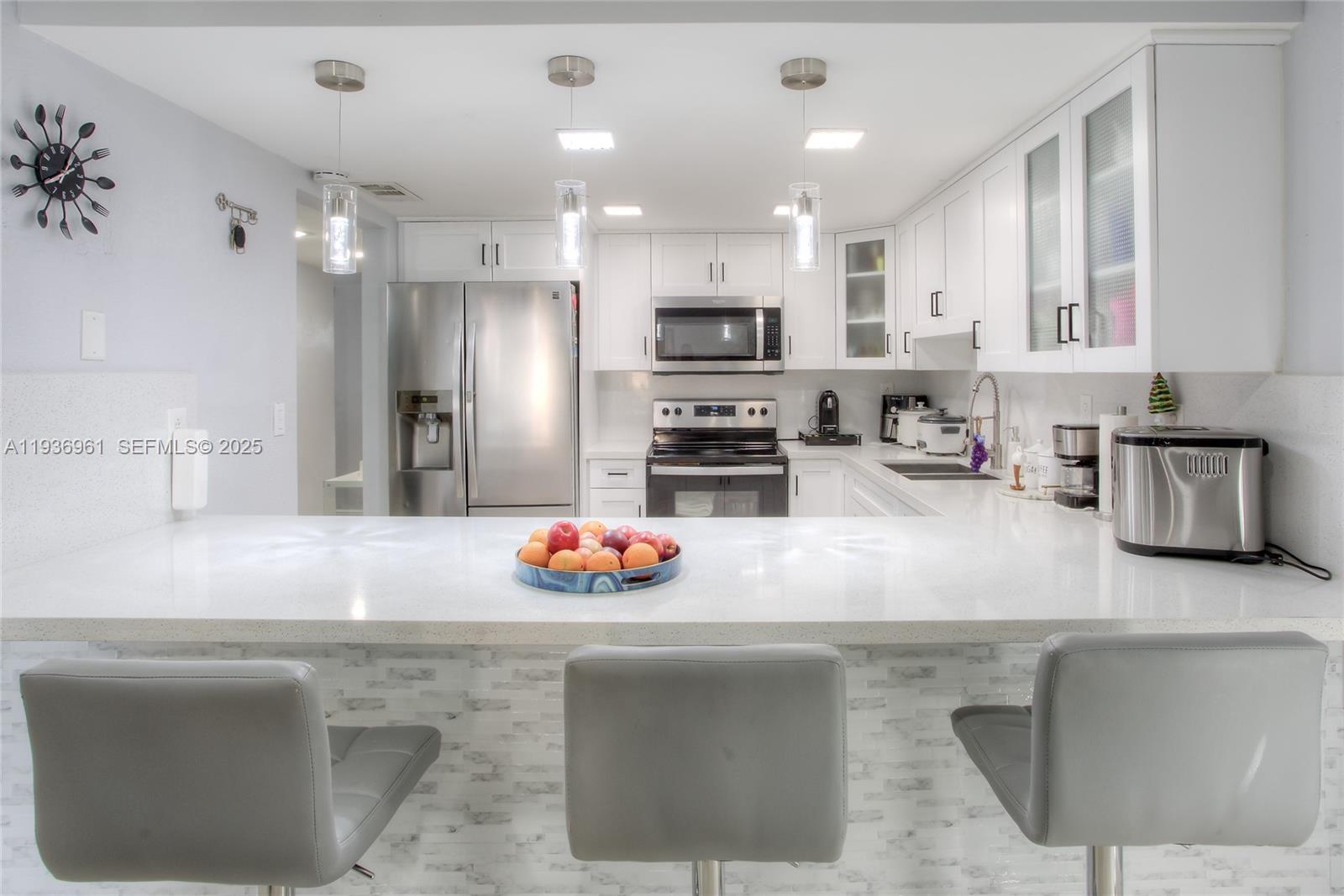 1925 West 72nd Street Hialeah, FL 33014 - Photo 5 of 15 a kitchen with stainless steel appliances granite countertop a sink a stove a refrigerator and cabinets