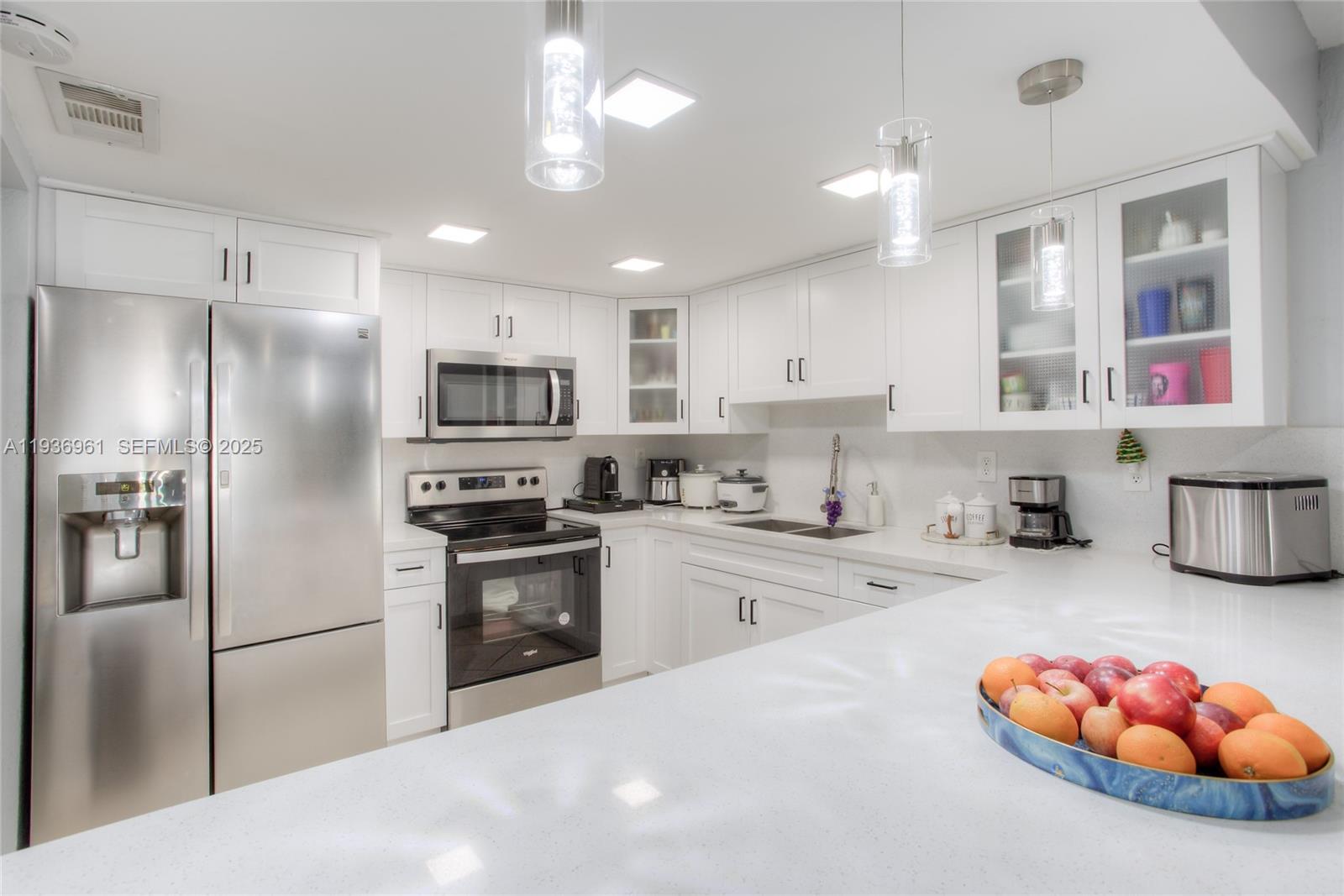 1925 West 72nd Street Hialeah, FL 33014 - Photo 6 of 15 a kitchen with stainless steel appliances granite countertop a refrigerator sink and stove