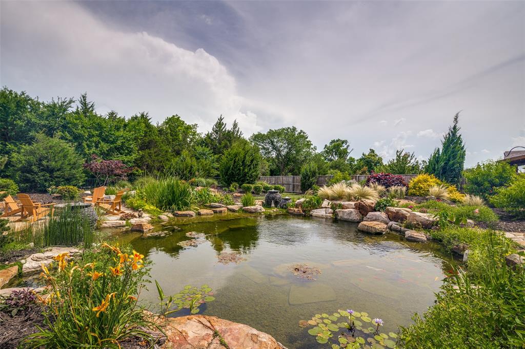 388 Bethany Road Sunnyvale, TX 75182 - Photo 36 of 40 Spacious backyard featuring a large koi natural swimming pond with a fountain, surrounded by natural rock landscaping and diverse plantings