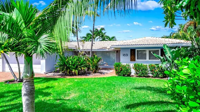 a front view of a house with a yard and potted plants