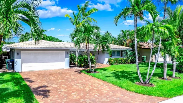 a front view of a house with a garden and trees
