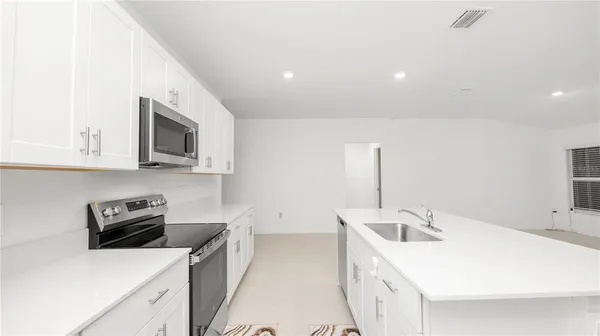 a kitchen with a sink a stove and cabinets