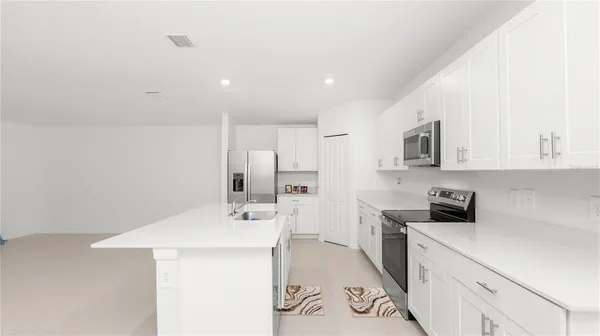 a kitchen with a sink a stove and cabinets