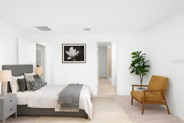 a bedroom with a bed and a potted plant
