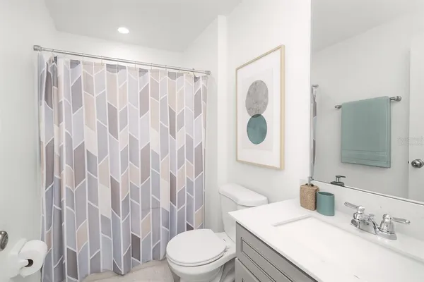 a bathroom with a sink a toilet and shower curtain