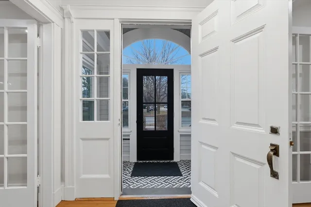 a kitchen with stainless steel appliances granite countertop a dining table chairs refrigerator and sink