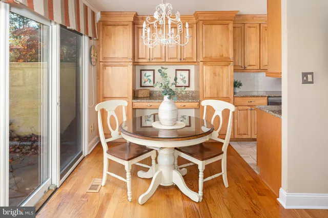 a dining room with furniture a chandelier and wooden floor