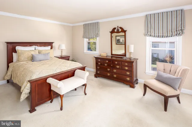 a bedroom with a bed and a dresser next to a window