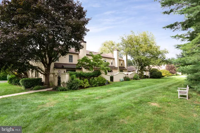 a front view of a house with a yard and trees