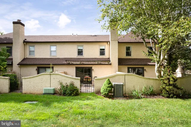 a view of a house with a yard and a large tree