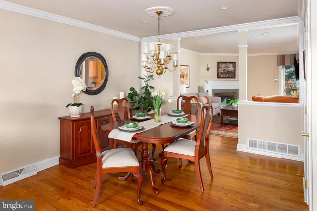 a dining room with furniture a chandelier and wooden floor