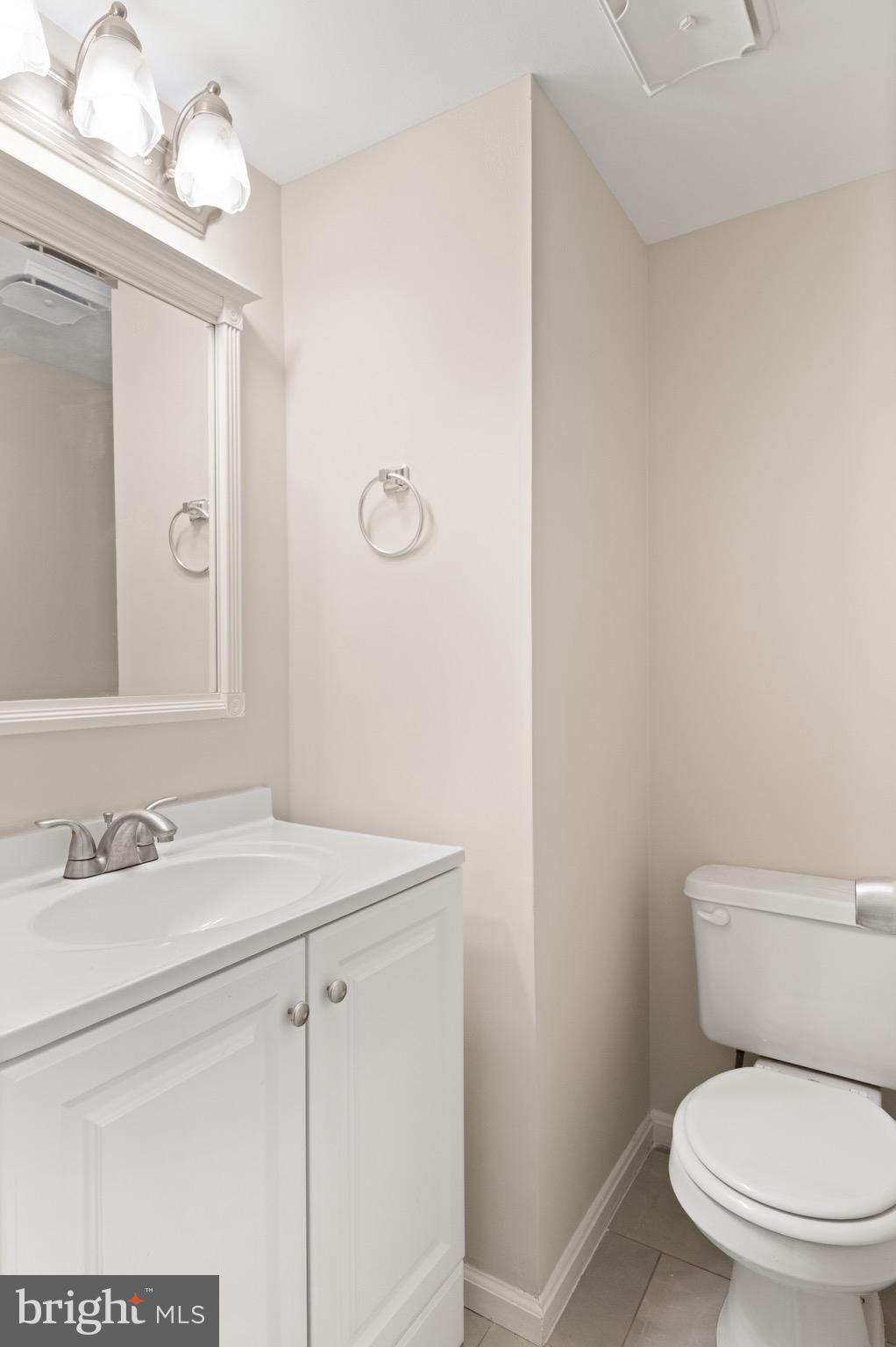 8581 Chester Grove Court Springfield, VA 22153 - Photo 19 of 38 a bathroom with a toilet sink vanity and mirror