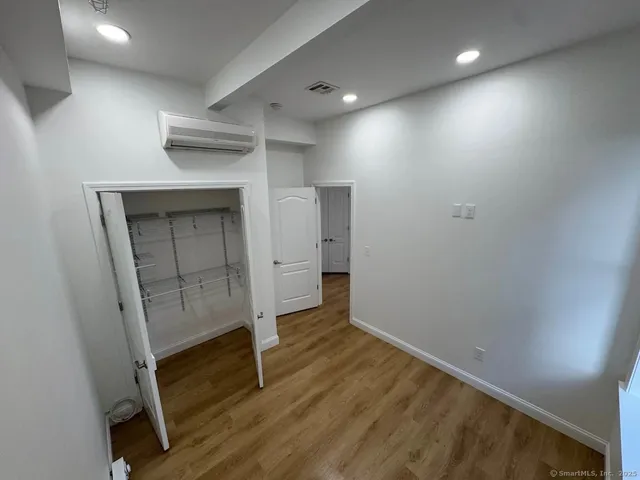 an empty room with wooden floor and cabinet