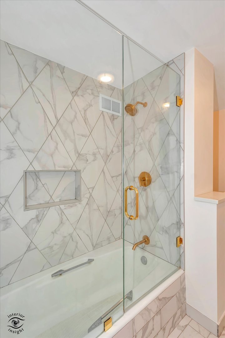 200 East Delaware Place, Unit 26E Chicago, IL 60611 - Photo 14 of 28 a bathroom with a bathtub and a shower