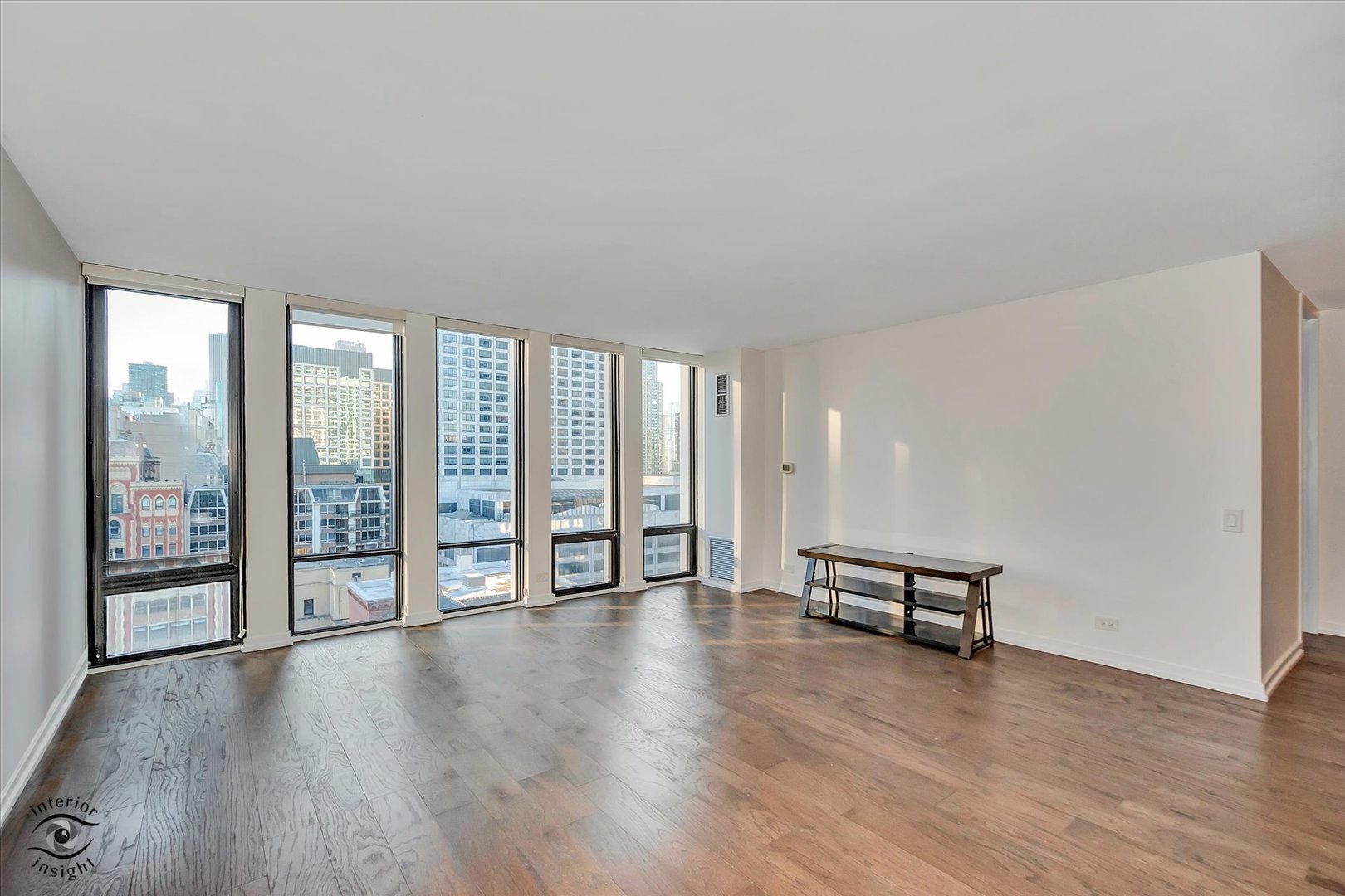 200 East Delaware Place, Unit 26E Chicago, IL 60611 - Photo 6 of 28 an empty room with wooden floor and windows