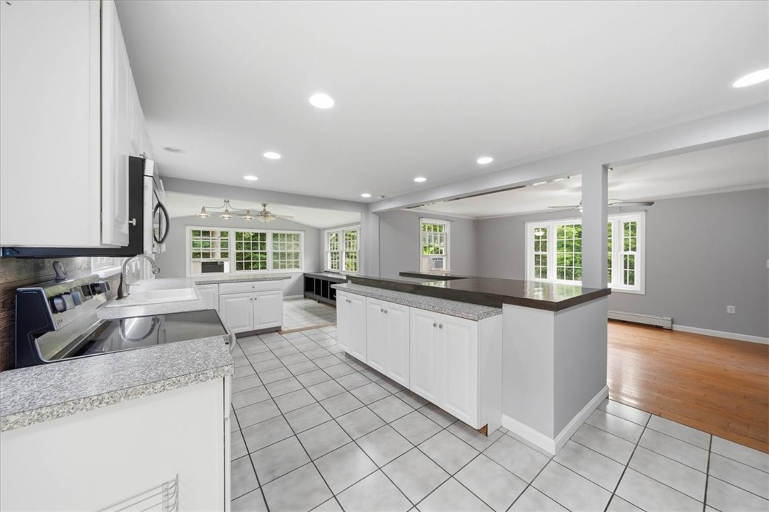 214 Anan Wade Road Glocester, RI 02857 - Photo 15 of 50 The expansive breakfast bar/pass-through adds additional serving and gathering space while maintaining an open connection to the living room—perfect for entertaining guests without being separated from the action.