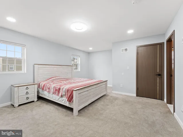 a spacious bedroom with a bed and a dresser