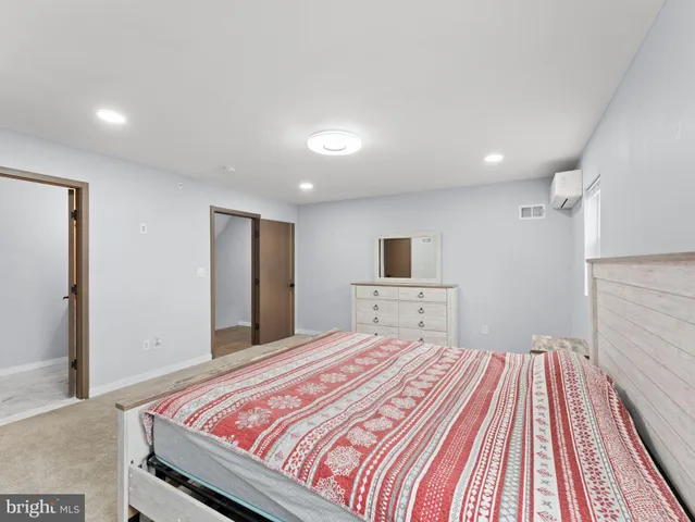 a bedroom with a bed and a view of kitchen