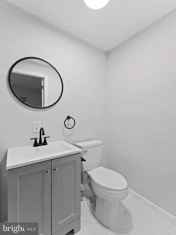 a bathroom with a toilet a sink and mirror