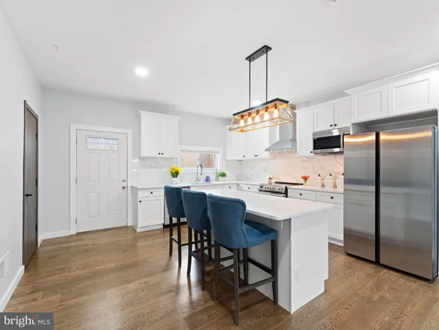 a kitchen with a refrigerator a table and chairs in it