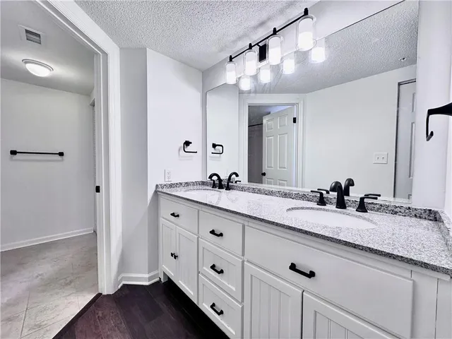a bathroom with double sink and a mirror
