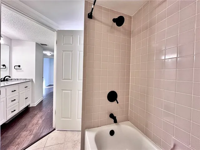 a bathroom with a tub a sink a shower and a mirror