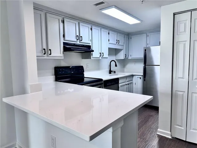 a kitchen with stainless steel appliances a refrigerator sink and cabinets