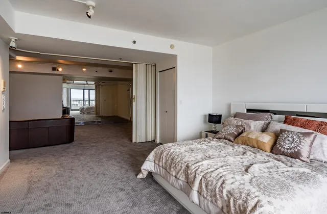 a spacious bedroom with a bed and a dresser