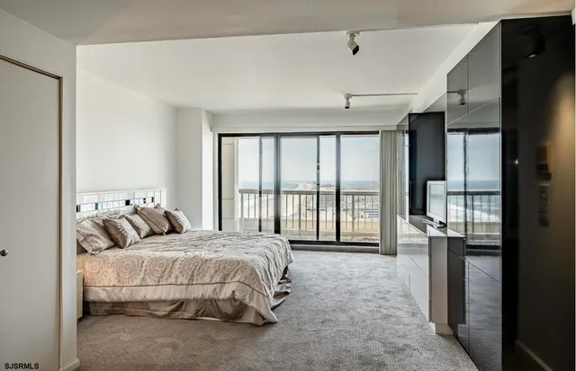 a bed sitting in a spacious bedroom next to a window