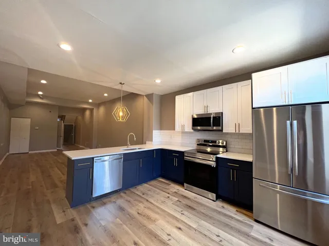 a kitchen with stainless steel appliances granite countertop a refrigerator and a sink