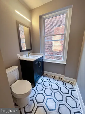 a bathroom with a toilet sink and mirror