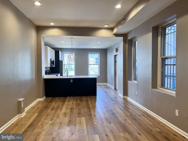 a living room with stainless steel appliances kitchen island granite countertop wooden floors and view living room