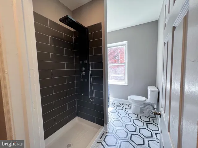 a bathroom with a toilet and a shower