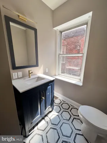 a bathroom with a sink vanity and a toilet