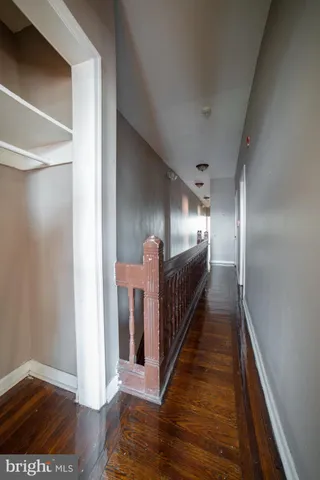 a view of a hallway with wooden floor and stairs