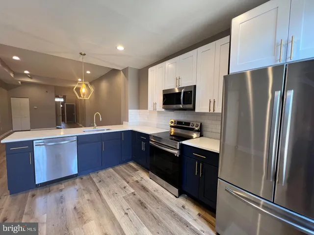 a kitchen with stainless steel appliances granite countertop a refrigerator a stove top oven a sink and dishwasher