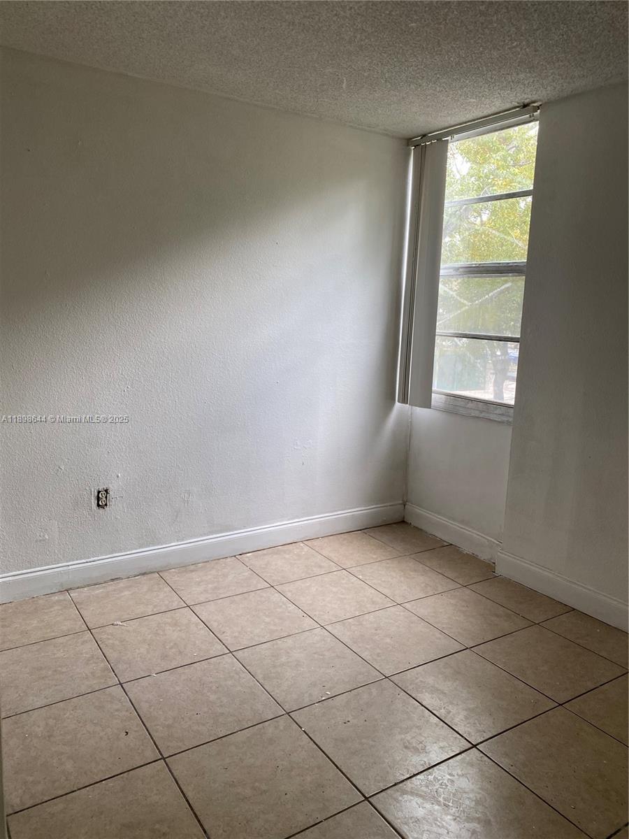 5959 Southwest 69th Street, Unit 106 Miami, FL 33143 - Photo 13 of 17 a view of an empty room with a window