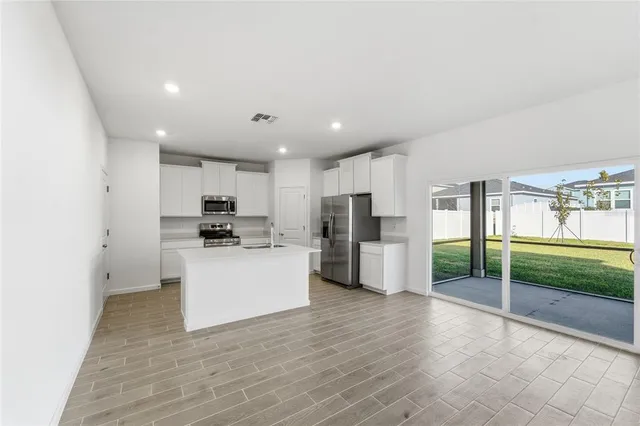 a kitchen with a refrigerator and a stove top oven
